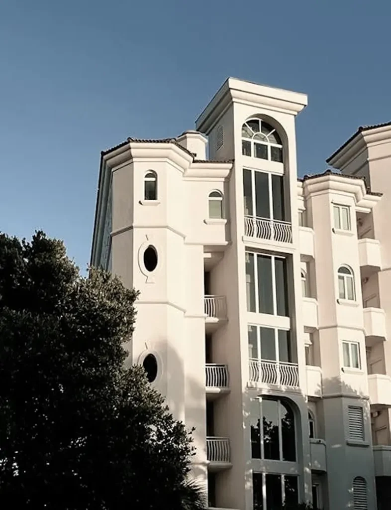 An expansive street view of a clean, high-end townhome community showing flawless roofing and immaculate white stucco building exteriors.