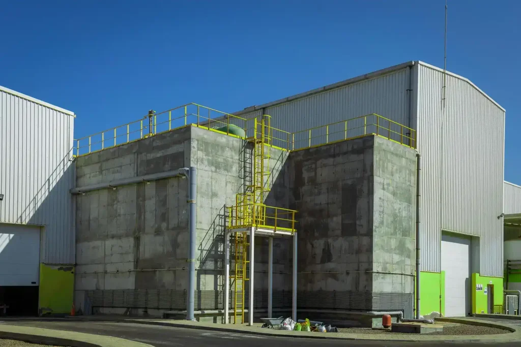 An expansive exterior view of a clean, white modern commercial warehouse facility showing pristine panels, structural walls, and service loading bays.